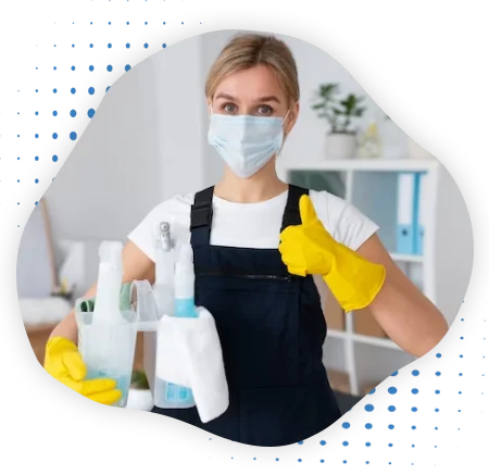 A lady cleaner holding cleaning equipment's and standing in office premises. 